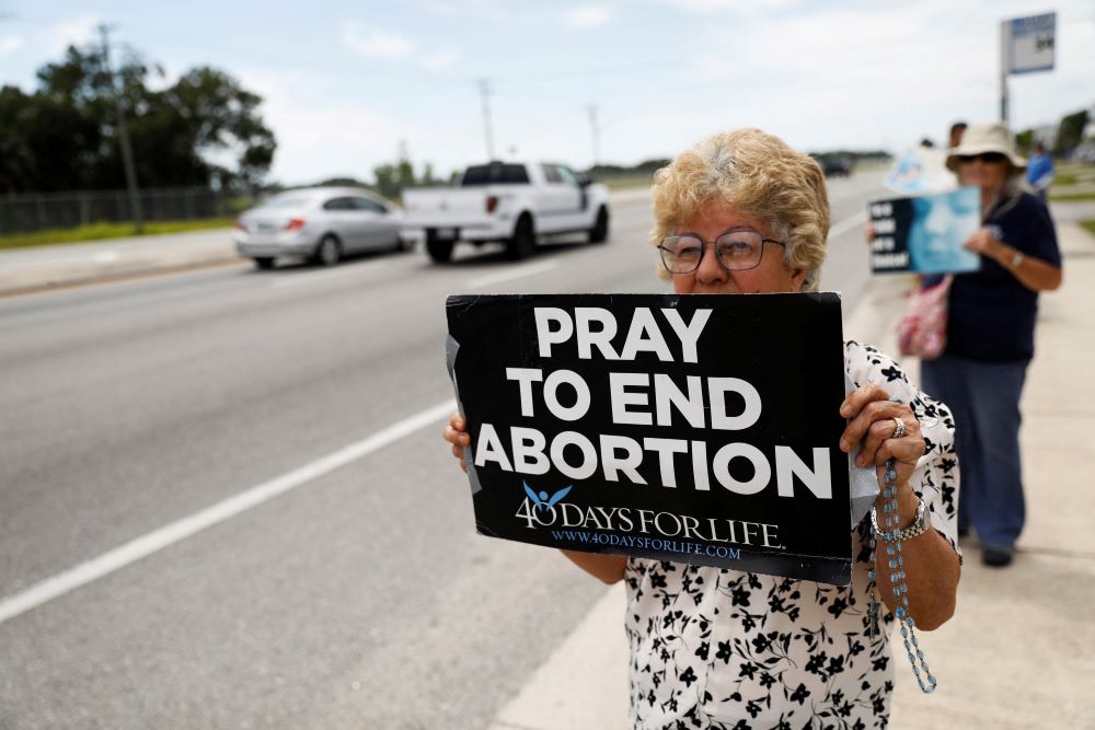 Woman holds pro-life sign. Woman holds pro-life sign.