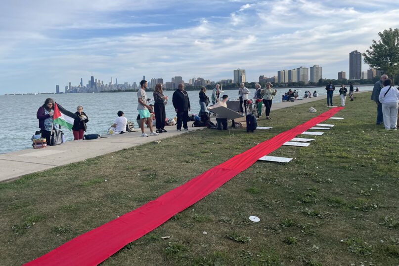 DNC Gaza protests, Aug. 20, 2024, Chicago. Daylight at lakeshore with Chicago skyline in background; long red ribbon stretches across entire frame.