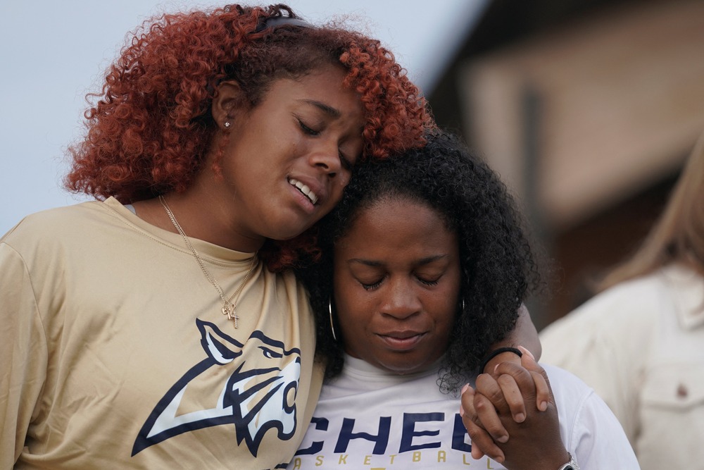 Apalachee High School shooting vigil, Jug Tavern Park, Winder, G.A., Sept. 4, 2024. Two women stand side by side, one has her arm around the other.