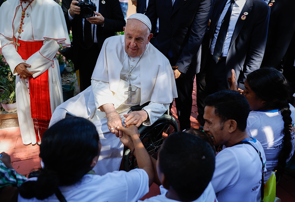 Pope Francis comforts a child during his visit with children who are seriously ill or have severe disabilities at the Irmas Alma School in Dili, East Timor, also known as Timor-Leste, Sept. 10. (CNS/Lola Gomez)