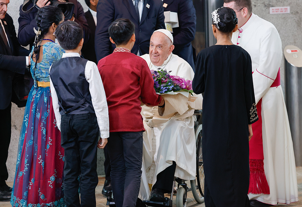 Pope Francis receives a bouquet of flowers from a group of children as he arrives Sept. 11 in Singapore, the last stop on his four-nation visit to Asia and the Pacific. (CNS/Lola Gomez) Pope Francis receives a bouquet of flowers from a group of children as he arrives Sept. 11 in Singapore, the last stop on his four-nation visit to Asia and the Pacific. (CNS/Lola Gomez)