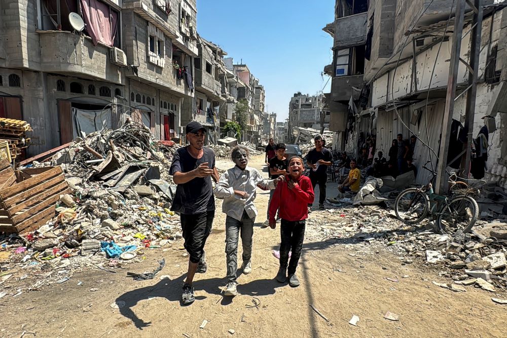 Palestinians react at the site of an Israeli strike that destroyed several houses in Khan Younis in the southern Gaza Strip. Palestinians react at the site of an Israeli strike that destroyed several houses in Khan Younis in the southern Gaza Strip.