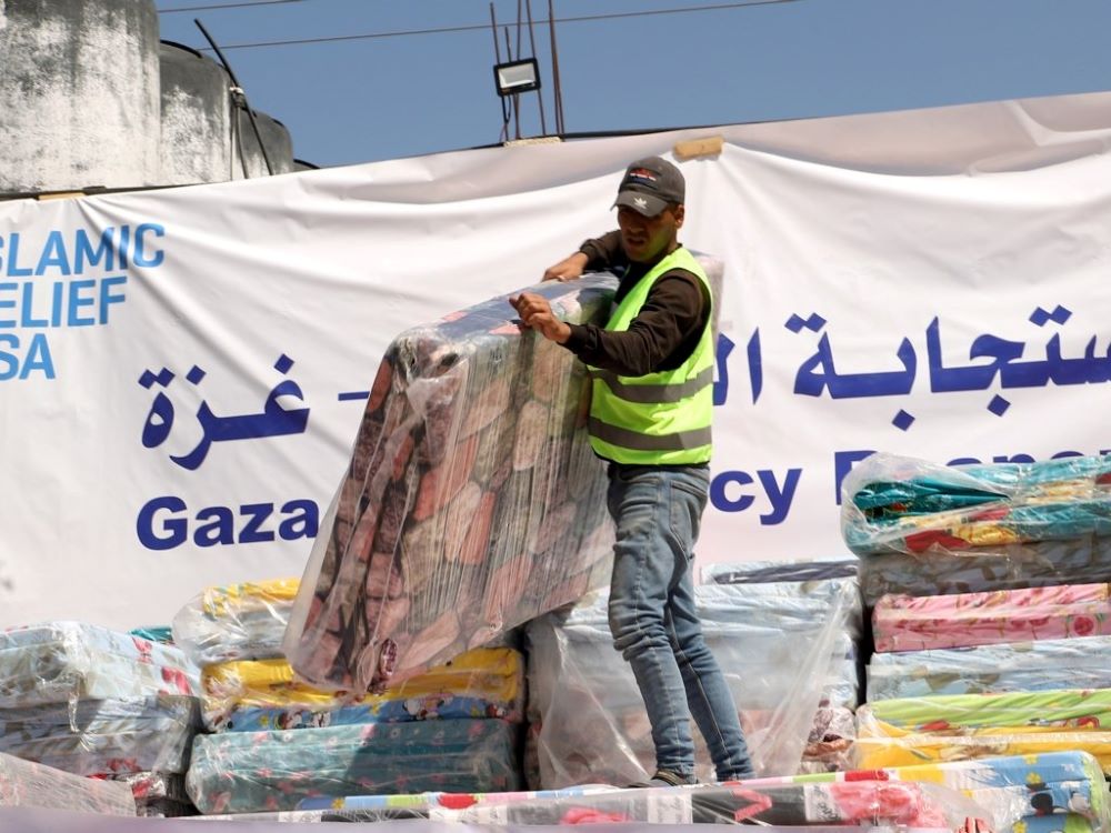 A humanitarian aid worker unloads mattresses supplied by Catholic Relief Services in Rafah, in the southern Gaza Strip, March 21. The mattresses will be distributed to people displaced in war-torn Gaza. (OSV News/Mohammad Al Hout for CRS) A humanitarian aid worker unloads mattresses supplied by Catholic Relief Services in Rafah, in the southern Gaza Strip, March 21. The mattresses will be distributed to people displaced in war-torn Gaza. (OSV News/Mohammad Al Hout for CRS)