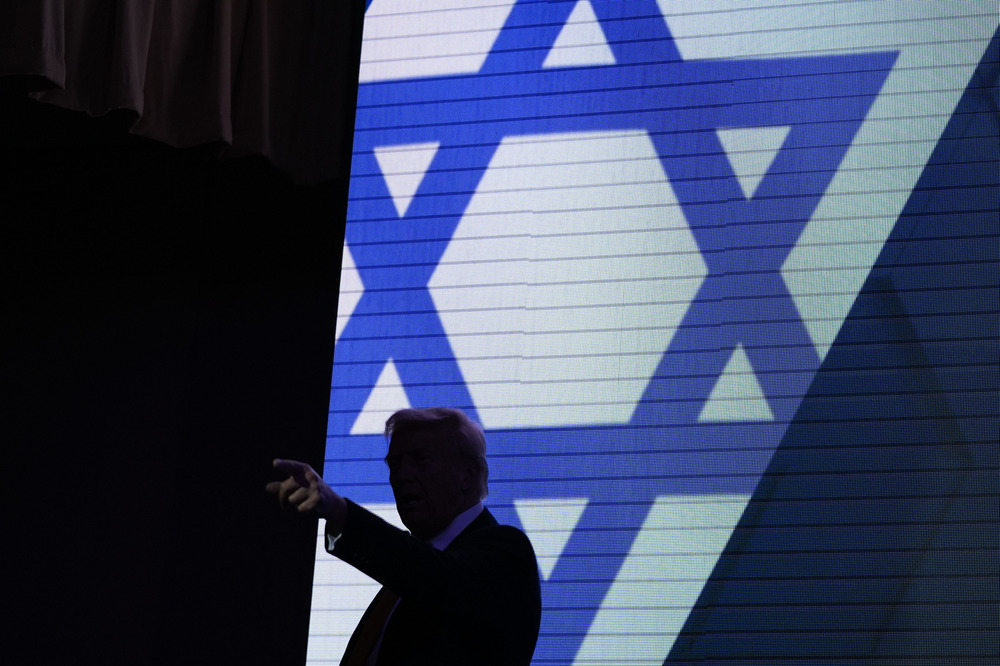 Donald Trump, Israeli American Council National Summit, Sept. 19, 2024, Washington D.C. Trump silhouetted against illuminated stage background of the Star of David.