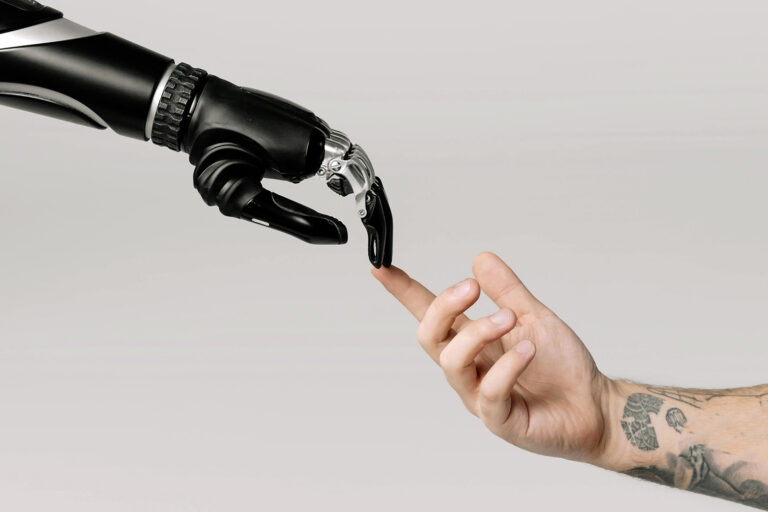 AI and human stock image. Photograph re-creation of "The Creation of Adam"; human hand reaches out to touch robotic arm.