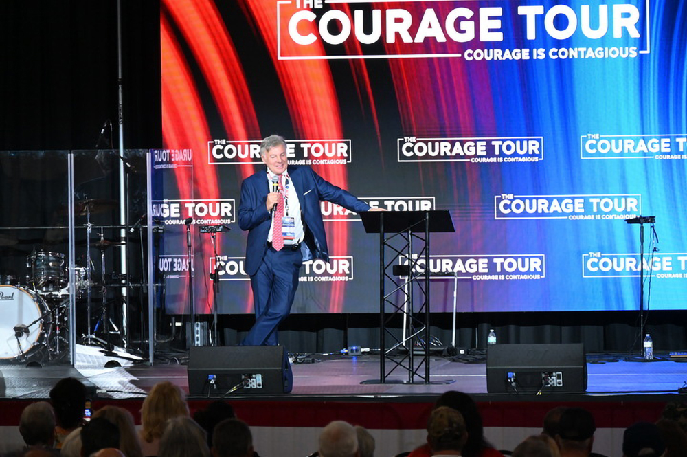 Lance Wallnau, self-proclaimed Christian nationalist pastor, speaking on his Courage Tour event in Monroeville, Pennsylvania, Sept. 28, 2024. Wallnau speaks on stage, leaning against lectern.