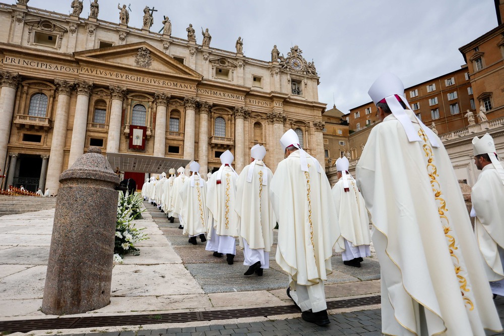 Opening Mass of the second session of the Synod on Synodality, Vatican City, Oct. 2, 2024. Long double-row of anonymous, vested bishops shown from behind file into looming edifice of St. Peter's.