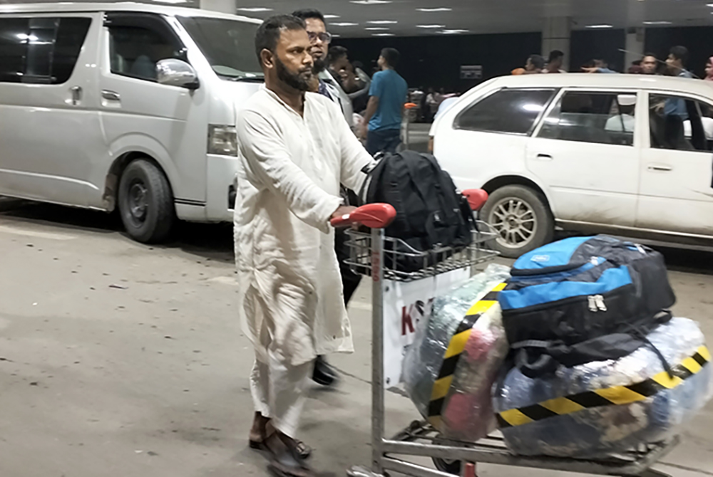 A Bangladeshi man heading to work abroad pushes luggage at the international airport in Dhaka, Bangladesh, on June 9, 2024. (NCR photo/Stephan Uttom Rozario)