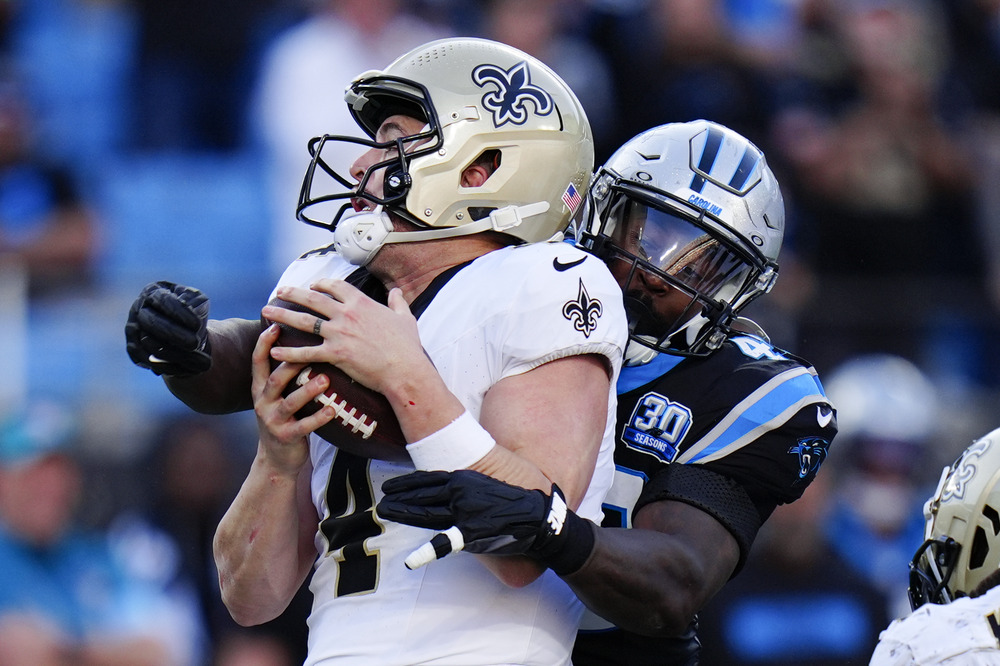 Derek Carr, Charles Harris, NFL game, Nov. 3, 2024, Charlotte, N.C. Action shot of one player tackling another.