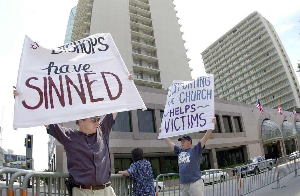 Dave and Larry West, Dallas, Texas, June 14, 2002. Protestors hold signs.