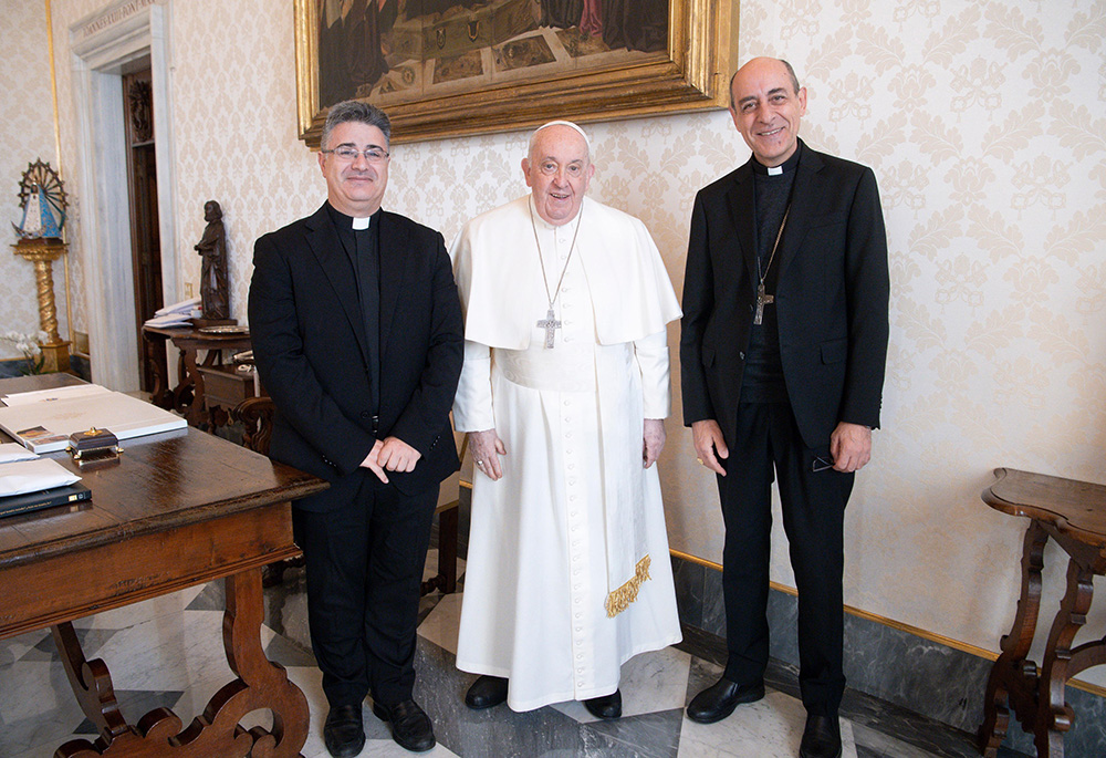Pope Francis poses for a photo with Msgr. Armando Matteo, left, secretary of the doctrinal section of the Dicastery for the Doctrine of the Faith, and Cardinal Víctor Manuel Fernández, dicastery prefect, during a meeting at the Vatican on Dec. 18, 2023, the date Fiducia Supplicans was released for publication. (CNS/Vatican Media)
