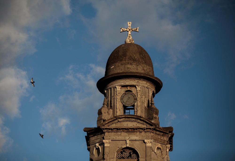 Old Metropolitan Cathedral, Managua, Nicaragua. Close-up of stone tower against blue and white sky.