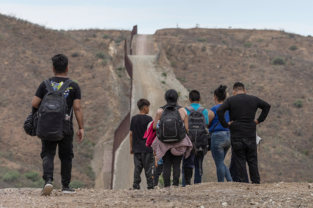 El muro fronterizo entre EE. UU. y México El muro fronterizo se ve en el fondo mientras los migrantes de América del Sur y Central buscan entregarse a los funcionarios de inmigración después de cruzar a los Estados Unidos desde México en Ruby, Arizona, el 24 de junio de 2024. (Foto: OSV News/Reuters/Adrees Latif)