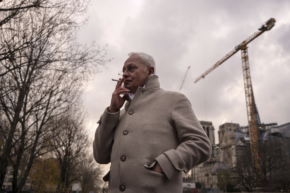 Phillipe Villeneuve, Dec. 3, 2024. Villeneuve wears coat, smoking, in background is massive crain.
