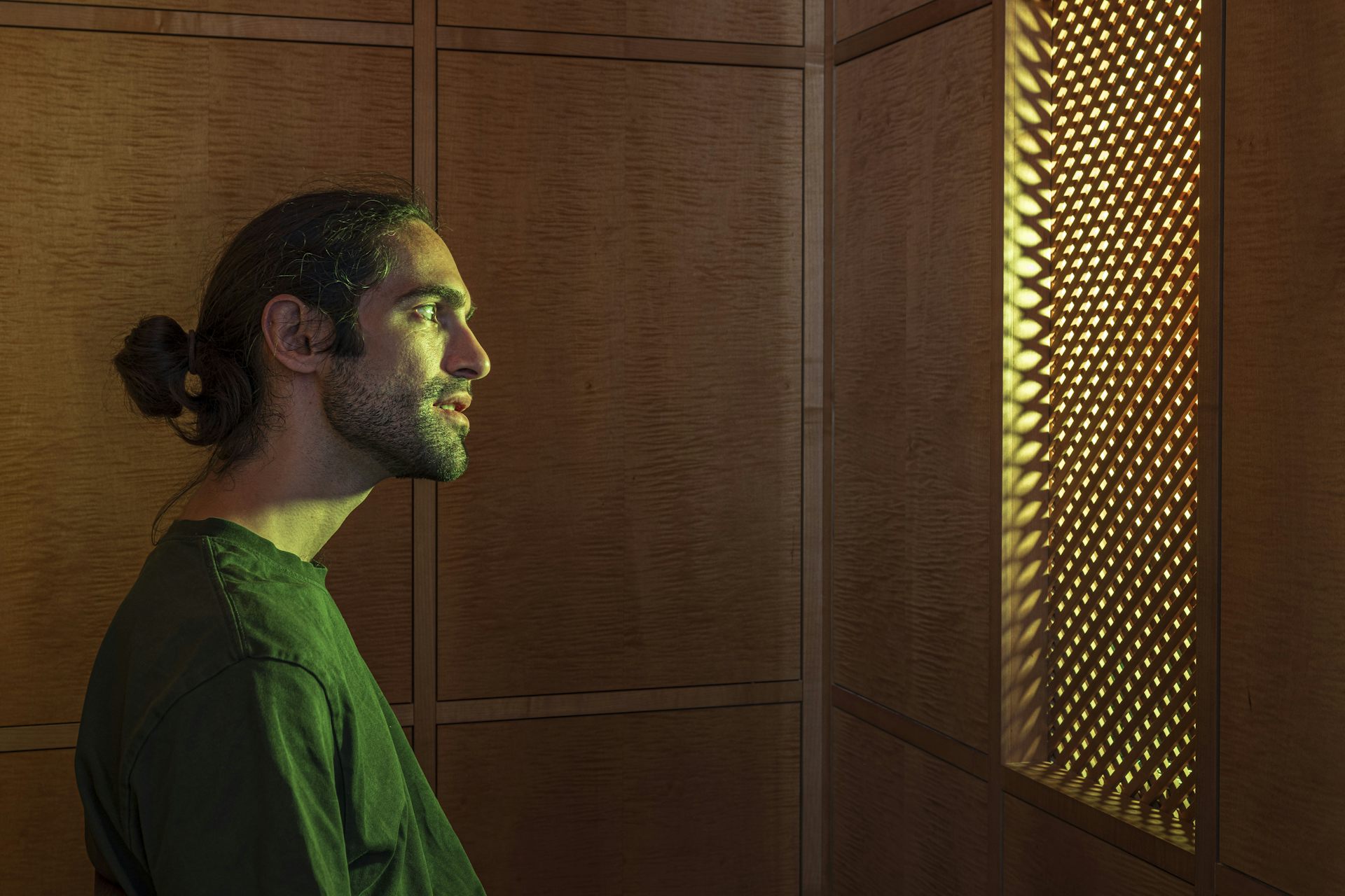 AI Jesus in confessional. AI image, Jesus wears modern garb and has hair tied back, listens warmly.