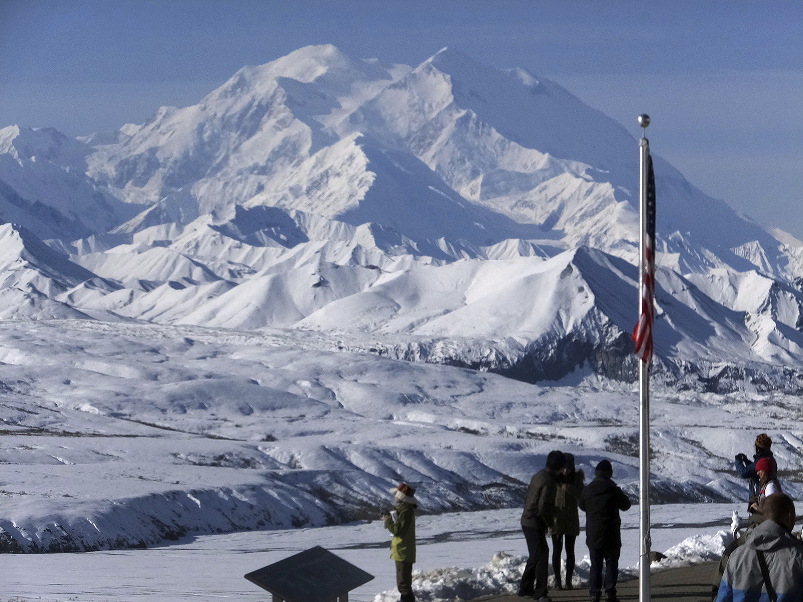 The then-Denali National Park and Reserve, renamed Mount McKinley by President Trump, Sept. 2, 2015. Peak in background, foregrounded are group of people and U.S. flag.