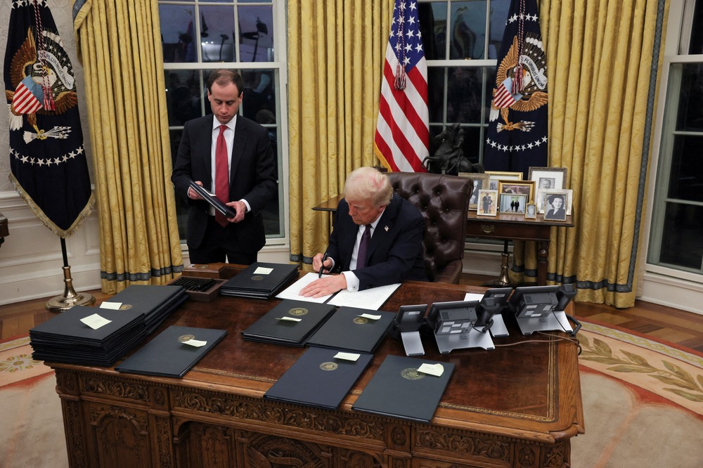President Trump executive orders, Oval Office, Washington D.C., Jan. 23, 2025. The president shown sitting at desk.