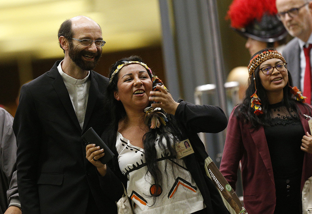 Fr. Dario Bossi, Patiachi Taylor and Leah Rose Casimero leave the final session of the Synod of Bishops for the Amazon at the Vatican Oct. 26, 2019. "If we don't put a break on global warming right now, we'll declare our defeat and get into a cycle of irreparable consequences and crises," Bossi told NCR. (CNS/Paul Haring)
