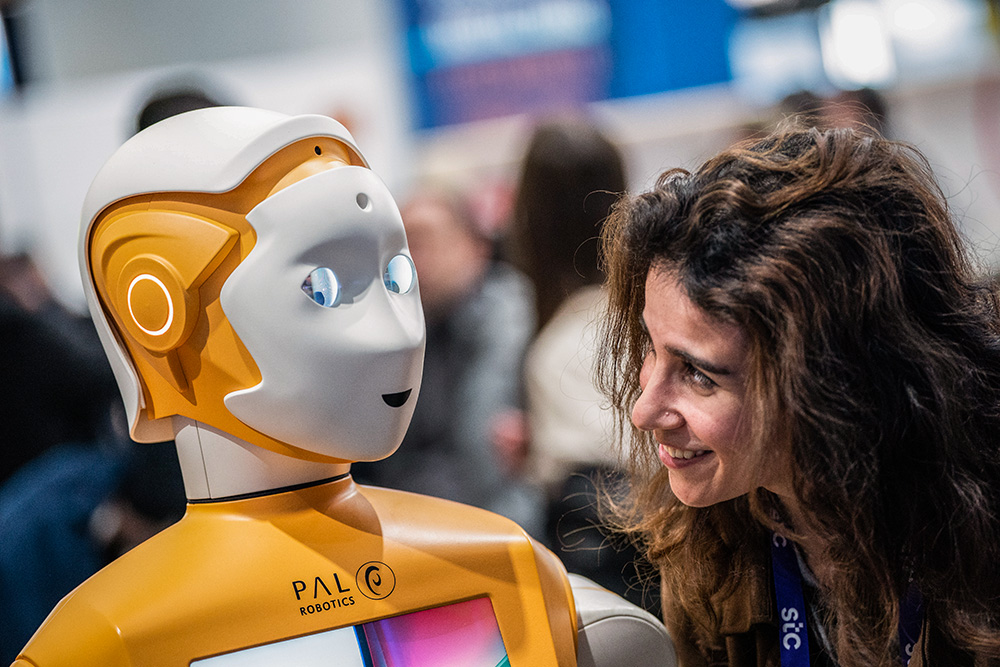 A visitor speaks with a PAL Robotic robot during the Mobile World Congress 2023 in Barcelona, Spain, on March 1, 2023. (AP/Joan Mateu Parra)