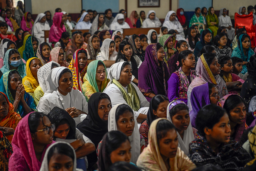 People, including priests and nuns, watch the Way of the Cross reenactment inside Dinajpur Cathedral. (Piyas Biswas)