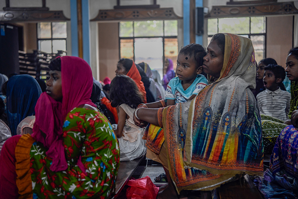 A child and his mother watch the Way of the Cross reenactment inside Dinajpur Cathedral. (Piyas Biswas)