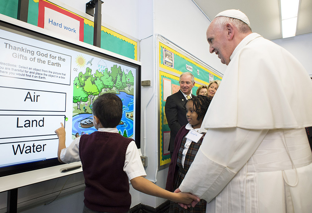 A student shows Pope Francis a lesson on the environment during his visit to Our Lady Queen of Angels School in the East Harlem area of New York on Sept. 25, 2015. (CNS photo)