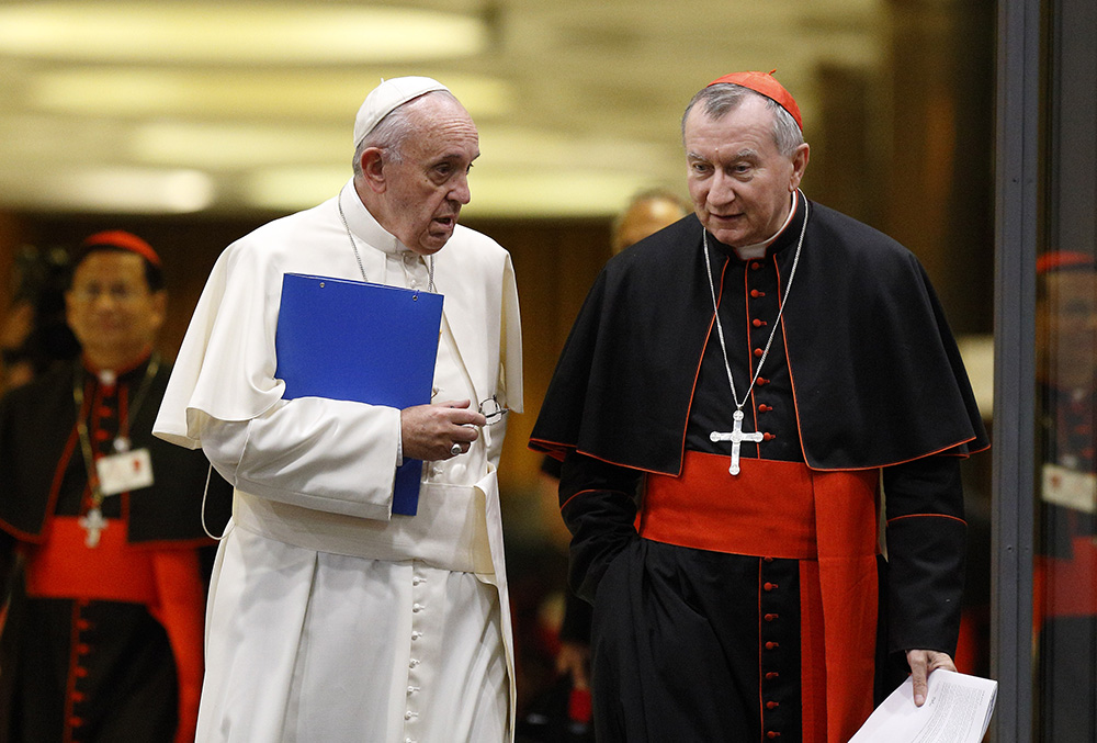 Pope Francis and Cardinal Pietro Parolin talk as they leave the opening session of the Synod of Bishops on the family at the Vatican Oct. 5, 2015. (CNS/Paul Haring)
