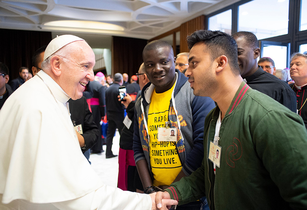 Pope Francis greets a youth delegate in 2018 before a session of the Synod of Bishops on young people, the faith and vocational discernment at the Vatican. (CNS/Vatican Media)