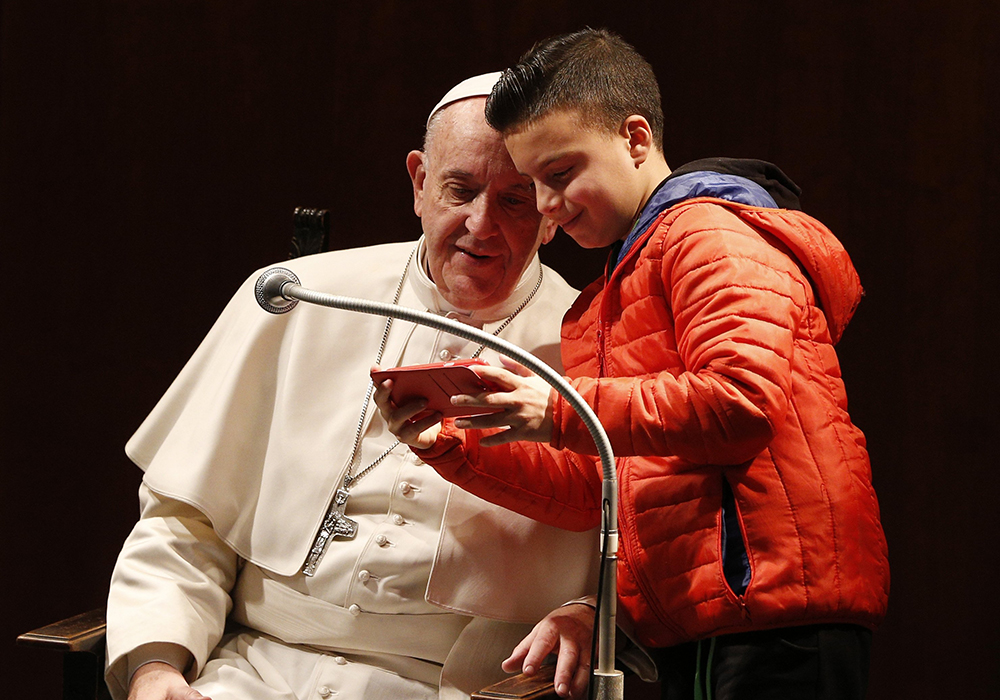 A boy takes a selfie with Pope Francis as the pope meets children before celebrating Mass at St. Mary Josefa Parish in Rome on Feb. 19, 2017. (CNS/Paul Haring)
