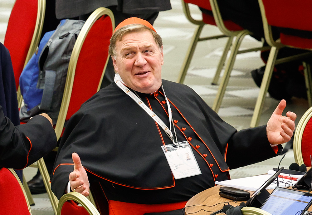 Cardinal Joseph Tobin of Newark, N.J., shares a moment with another cardinal during a break in the opening session of the Synod of Bishops in the Vatican's Paul VI Audience Hall Oct. 2, 2023. (CNS/Lola Gomez)