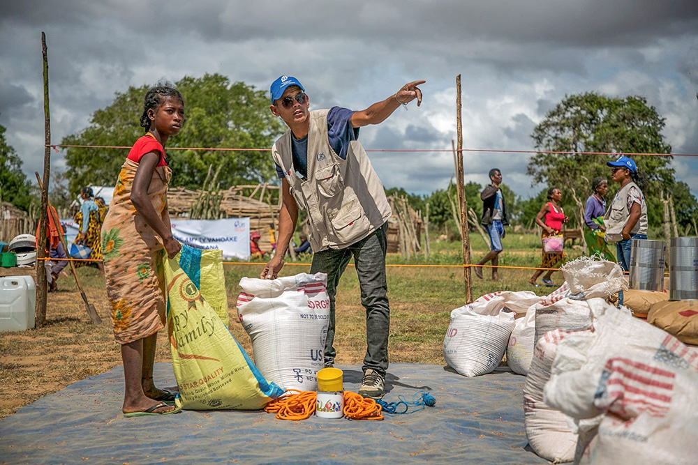A Catholic Relief Services worker is pictured in a file photo helping a young woman at a food distribution area in Marojela village, located in the Marolinta commune in southern Madagascar's Beloha District. (OSV News/Courtesy of Catholic Relief Services/Jim Stipe)