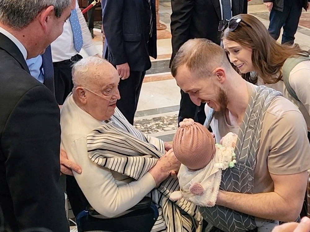 Pope Francis, who is continuing to recover from pneumonia and a long hospitalization, blesses a baby as he makes a surprise visit to St. Peter's Basilica at the Vatican, April 10, 2025, in this screengrab taken from a handout video. (OSV News/Reuters/Luiz Gil)