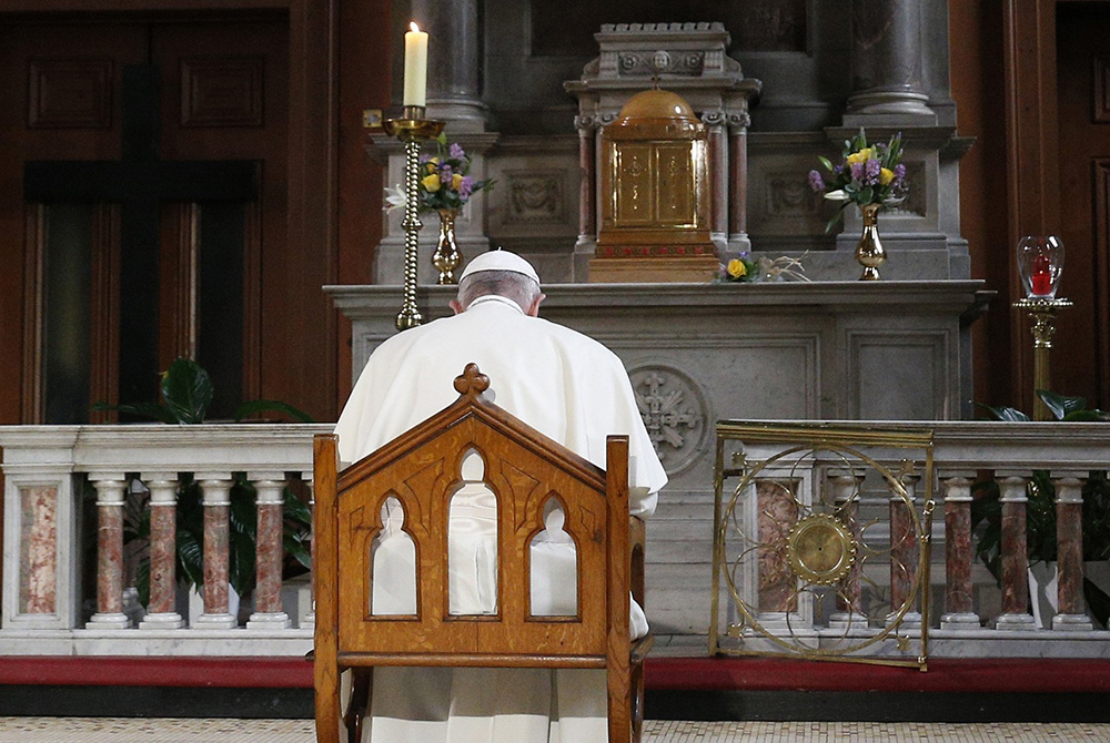 Pope Francis prays in front of a candle in memory of victims of sexual abuse as he visits St. Mary's Pro-Cathedral in Dublin Aug. 25, 2018. (CNS/Paul Haring)