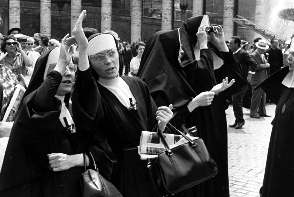 Roman Catholic nuns in St. Peter's Square stand watching smoke (unseen) coming from the chimney on roof of the Sistine Chapel June 20, 1963. (AP Photo)