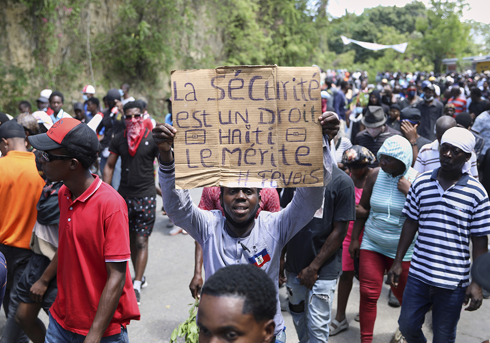A protester holds up a sign that reads in French, "Security is a right, Haiti deserves it" during a protest against insecurity April 2 in Port-au-Prince, Haiti. Two women religious, Sr. Evanette Onesaire and Sr. Jeanne Siliane Voltaire, were killed March 31. (AP photo/Odelyn Joseph)