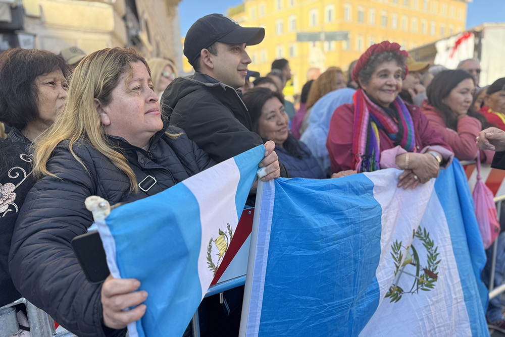 A group of Guatemalan migrants to Italy hold the flag of their country near the Basilica of St. Mary Major in Rome April 26, 2025, just before the arrival of Pope Francis' coffin. They said they feel they have not only lost a religious leader but also a friend and defender. (NCR photo/Rhina Guidos) 