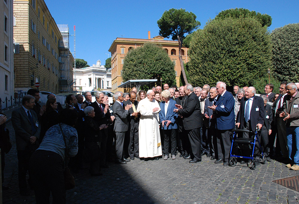 Pope Francis stands outside of Casa Santa Marta with attendees of a Pontifical Academy of Sciences meeting on the environment and climate change, in May 2014. Dan Misleh's head appears above the woman in the blue blazer to the right of Francis. (Courtesy of Dan Misleh)