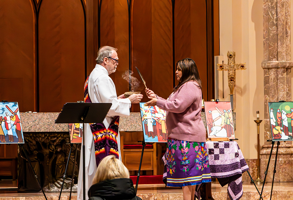 Deacon Bill Frere and Jody Roy, both of the St. Kateri Center of Chicago, conduct a smudging ceremony with an eagle feather and sage in Holy Name Cathedral in Chicago, prior to an April 11 Stations of the Cross centered on Native Americans. The devotion's prayers, composed by a permanent deacon with Indigenous ancestry, meditate on the suffering of Native people while calling for the faithful to stand in solidarity and work for justice. (Courtesy of Jade Roy)