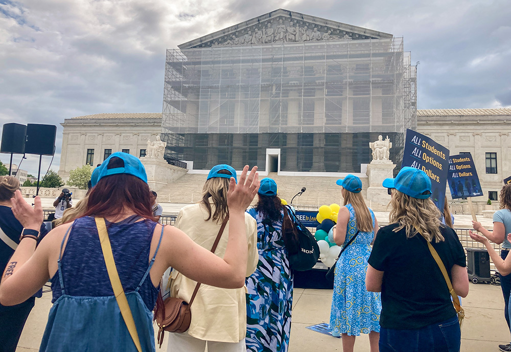 Demonstrators in front of the Supreme Court join in song during a rally to support St. Isidore of Seville Catholic Virtual School in Oklahoma in its fight for approval from the U.S. Supreme Court for state taxpayer support. (NCR photo/Carol Zimmermann)