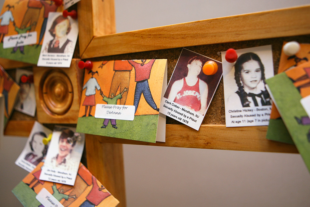 A cross outside the U.S. bishops' Office of Child and Youth Protection is covered with photos and prayers for the victims of clergy sexual abuse in a 2011 file photo. (CNS/Nancy Wiechec)