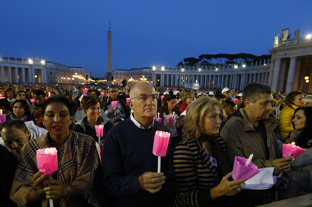 People hold candles during a prayer vigil for the Synod of Bishops on the family attended by Pope Francis in St. Peter's Square at the Vatican Oct. 3, 2015. (CNS/Paul Haring)