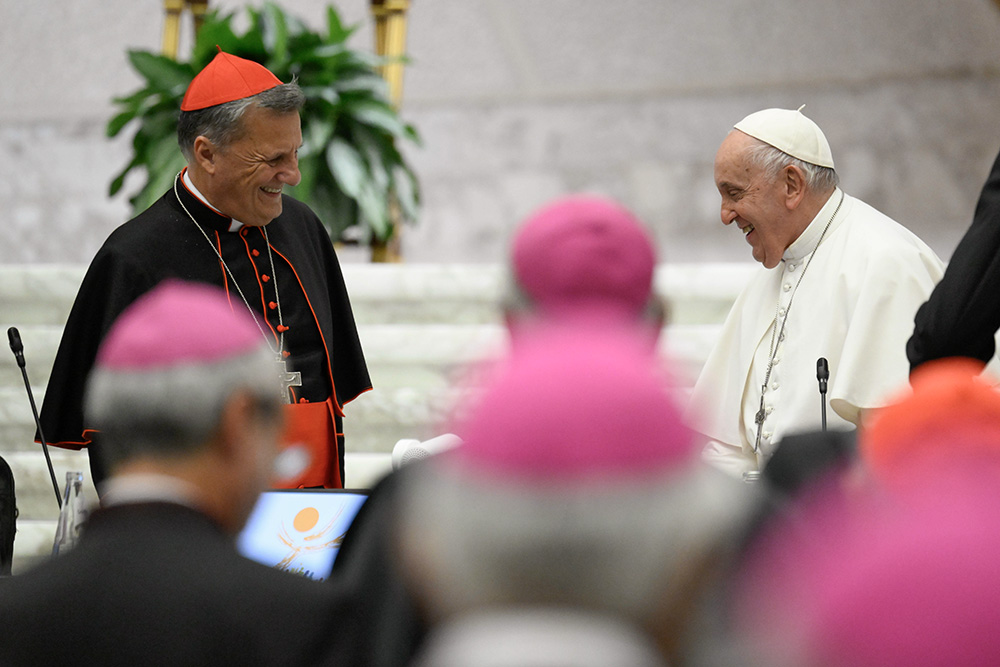 Pope Francis smiles at Cardinal Mario Grech as the first assembly of the synod on synodality concludes Oct. 28, 2023, in the Paul VI Hall at the Vatican. (CNS/Vatican Media)