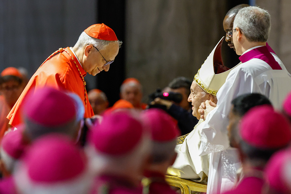 Pope Francis hands Cardinal Robert Prevost, the future Pope Leo XIV, a copy of Spes Non Confundit, ("Hope Does Not Disappoint"), his document proclaiming the Holy Year 2025, during a ceremony in front of the Holy Door of St. Peter's Basilica at the Vatican May 9, 2024. (CNS/Lola Gomez)