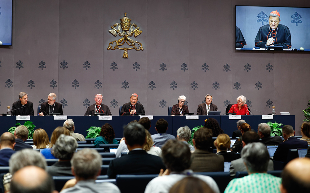 Members of the General Secretariat of the Synod, including Cardinal Mario Grech (at center and onscreen), attend a news conference at the Vatican Oct. 26, 2024. (CNS/Lola Gomez)