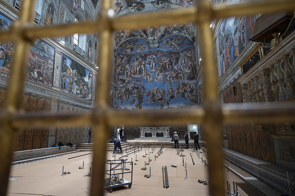 In preparation for the conclave to elect a new pope, workers build platforms over a protective covering on the marble floor of the Sistine Chapel at the Vatican May 2, 2025. The cardinals who enter the conclave May 7 will sit at tables facing the center with the tables in the back row raised slightly. (CNS/Vatican Media)
