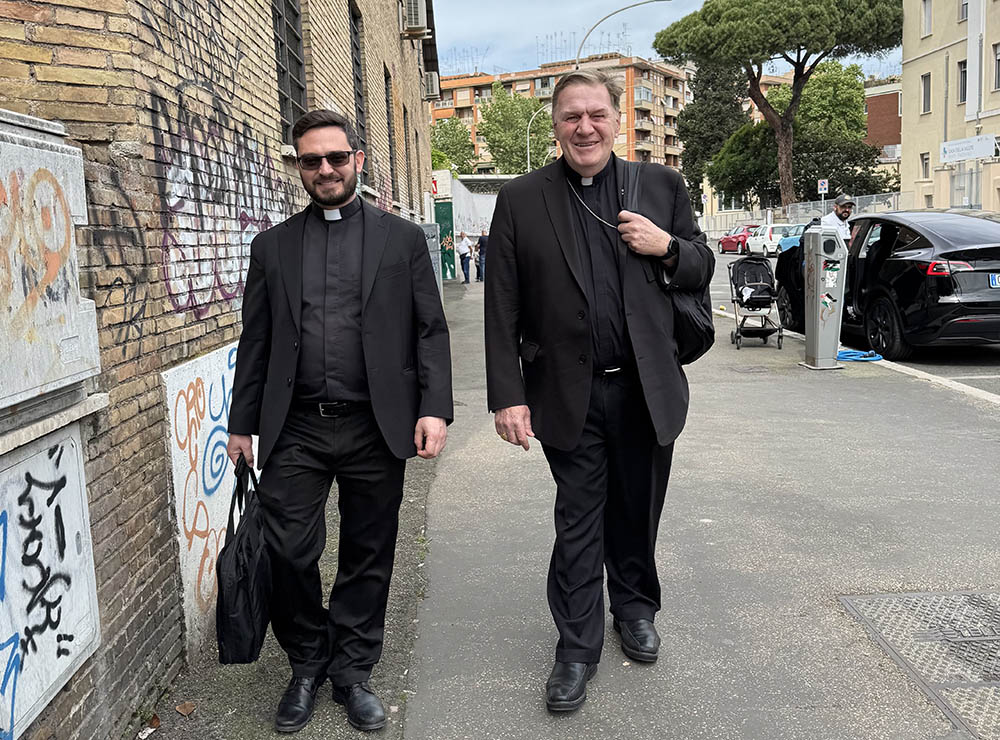 Cardinal Joseph Tobin of Newark, N.J., and his secretary, Fr. Anthony Palombo, walk from the subway stop to Mass at Santa Maria delle Grazie, the cardinal's titular church in Rome, May 4, 2025. (CNS/Cindy Wooden)