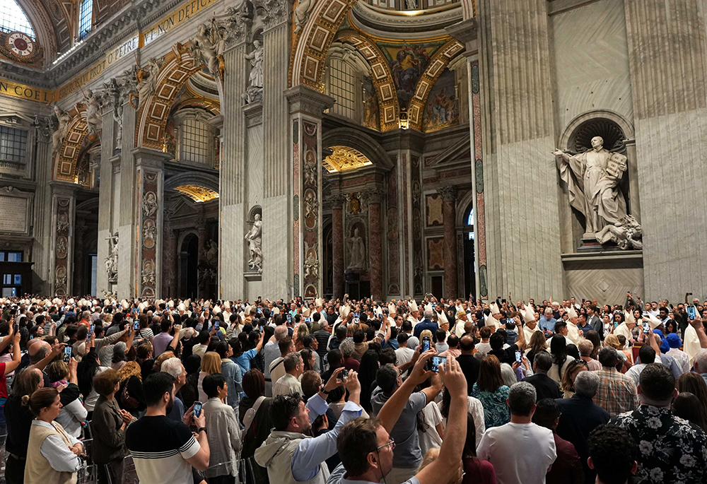 People use their phones to take photos as cardinals process into St. Peter's Basilica at the Vatican for Mass on the final day of the official mourning for Pope Francis on May 4, 2025. (CNS/Lola Gomez)