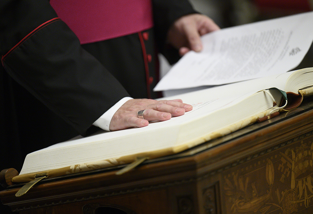 A prelate takes an oath of secrecy May 5, 2025, in preparation for the conclave at the Vatican to elect a new pope. The staff of the cardinals' residence hall, medical assistants and even the cardinals' bus driver took an oath swearing to protect the cardinals' privacy and the conclave's secrecy. (CNS/Vatican Media)