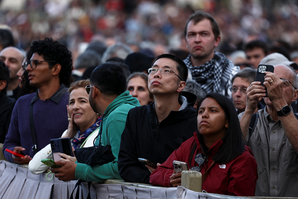 People wait for the smoke to rise from the chimney in St. Peter's Square at the Vatican on the evening of May 7, 2025, as cardinals gather in the Sistine Chapel on the first day of the conclave to elect a new pope. (OSV News/Reuters/Yara Nardi)
