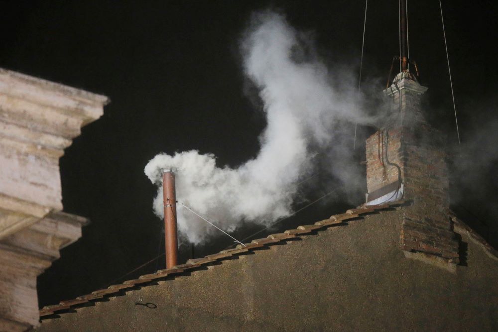 White smoke billows from the chimney of the Sistine Chapel.